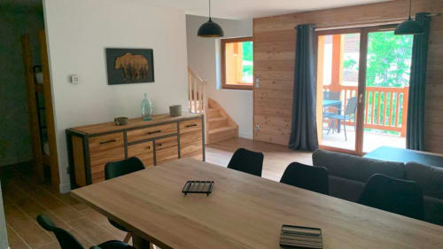 Salon de l'appartement à Vars-les-Claux, avec vue sur le balcon, créant un espace lumineux et agréable pour se détendre tout en profitant de l'air frais et du paysage montagnard.