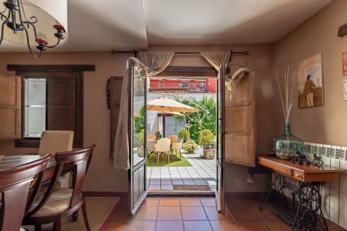 Salle à manger de Casa Peregrinando à Navarrete avec portes-fenêtres ouvertes sur la zone de détente extérieure