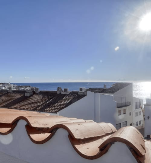Vue panoramique depuis une terrasse à Palafrugell : la mer Méditerranée, bâtiments blancs et toits de tuiles espagnoles traditionnels à Finques