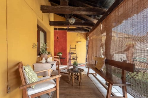 Terrasse rustique couverte de Casa Peregrinando à Navarrete avec mobilier en bois, murs jaunes et détails en brique