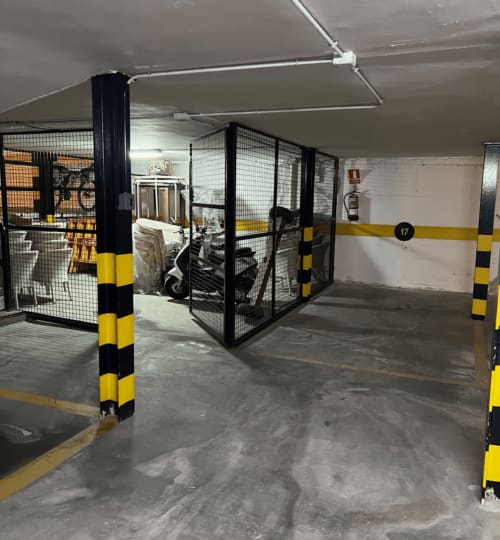 Secure underground parking garage at Finques Garcia Enrich in Palafrugell with numbered spaces and yellow safety markings