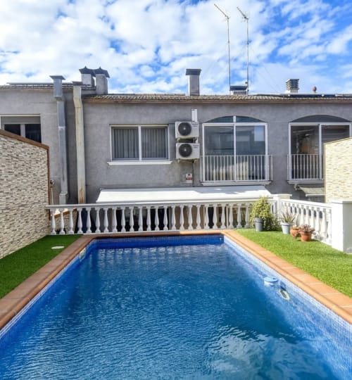 Backyard swimming pool at Finques Garcia Enrich hotel in Palafrugell, Spain with lush green lawn and modern terrace