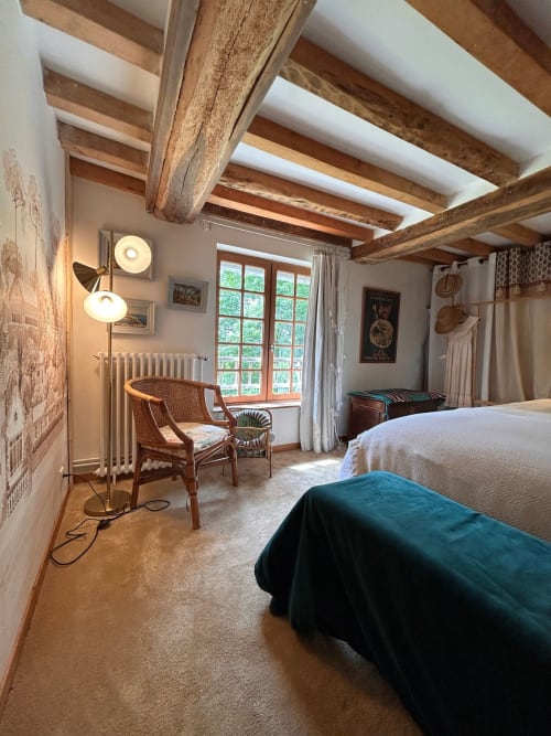 Chambre rustique au Domaine de Blanvatel avec poutres apparentes, cheminée et vue sur la campagne