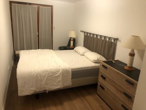 Chambre de l'appartement 202 dans la résidence VARSEA à Vars-les-Claux, équipée d'un lit double confortable, offrant un espace intime et reposant avec une décoration chaleureuse et montagnarde