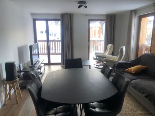 Vue de l'autre côté du salon et de la cuisine de l'appartement 202 dans la résidence VARSEA à Vars-les-Claux, avec un accès direct au balcon, offrant une belle vue sur les montagnes et un espace extérieur pour profiter de l’air frais