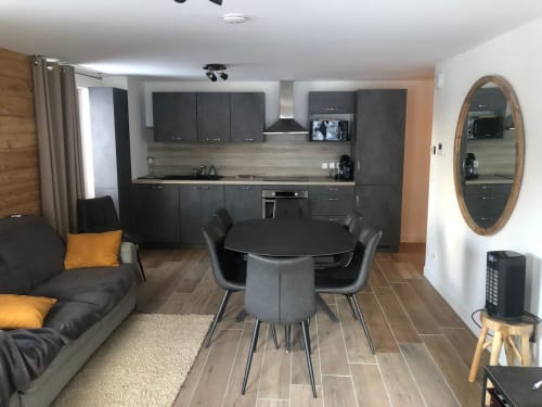 Cuisine et salon de l'appartement 202 dans la résidence VARSEA à Vars-les-Claux, un espace ouvert et convivial, alliant confort moderne et ambiance montagnarde, idéal pour des moments de détente en famille ou entre amis après une journée de ski