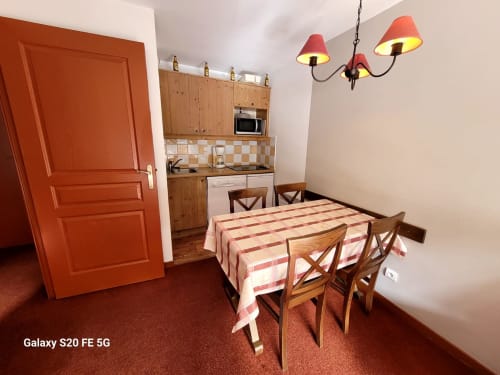 Cuisine moderne de l'appartement B06 dans la résidence l'Albane à Vars-les-Claux, équipée de tout le nécessaire pour préparer vos repas, avec une table à manger conviviale pour partager des moments agréables en famille ou entre amis.