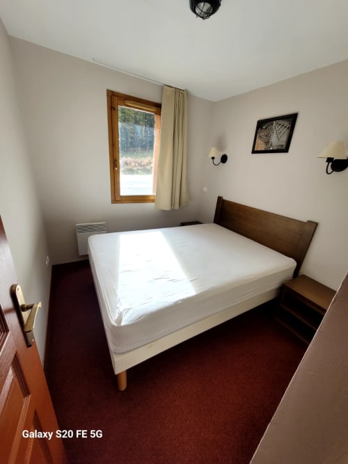 Chambre de l'appartement B06 dans la résidence l'Albane à Vars-les-Claux, équipée d'un lit double confortable, offrant un espace reposant et cosy, idéal pour se détendre après une journée sur les pistes