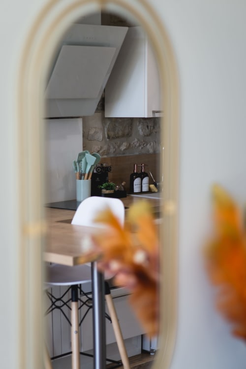 L'espace de travail du cottage La Romance aperçu par la porte, avec bureau, chaise et mur en pierre, vue sur le jardin de Bagard