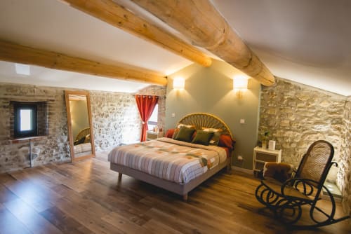 Chambre rustique en pierre à La Romance, Bagard, avec poutres apparentes, parquet et vue sur le jardin