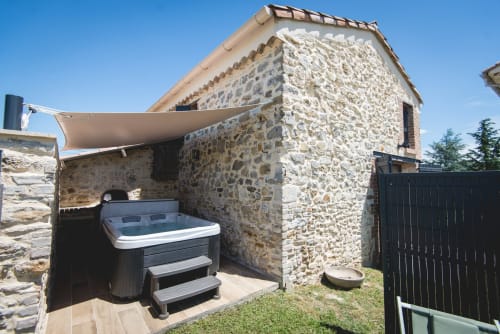 Vue jardin du gîte en pierre avec bain à remous à La Romance, Bagard - refuge rustique à la campagne
