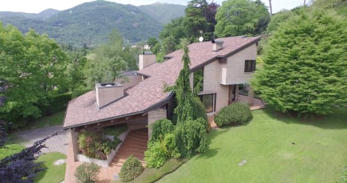 Appartamento Casa_B a Erba con tetto in cotto, prato curato e vista sulle montagne circondata da rigogliosa vegetazione