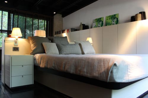 Camera moderna a Casa_B Erba con vista sulla piscina: letto con cuscini grigi, comodino bianco, lampade a sospensione e scaffali.