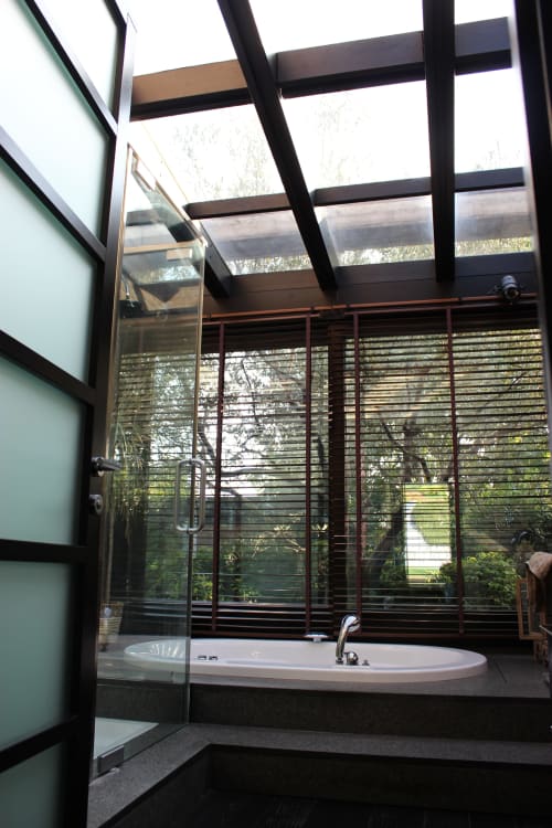 Bagno moderno con vasca ovale per relax e lucernario nella residenza Casa_B di Erba, vista piscina attraverso schermi a stecche