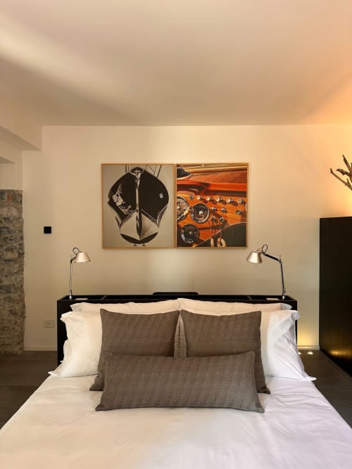 Camera moderna a Casa_B a Erba con letto nero, cuscini grigi, opera d'arte auto vintage e illuminazione calda