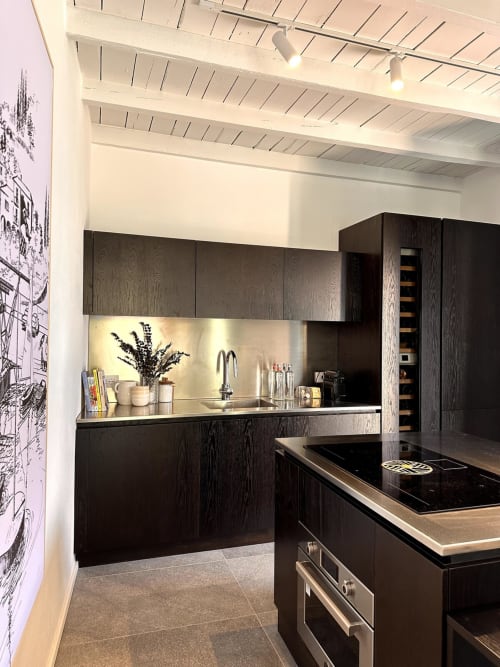 Cucina moderna in legno scuro con piano in acciaio inox e elettrodomestici presso l'appartamento Casa_B a Erba