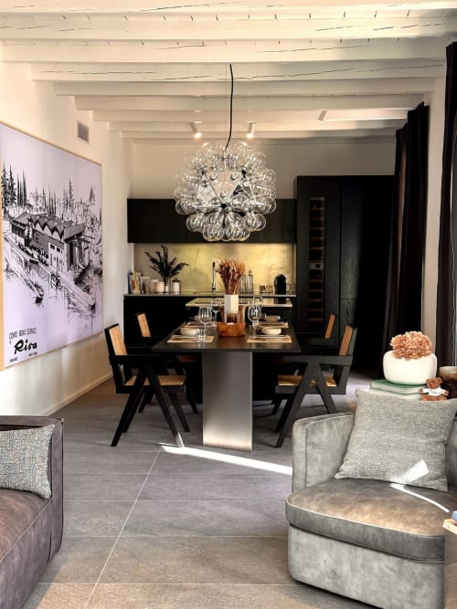 Zona pranzo moderna di Casa_B a Erba con tavolo nero, lampada a sospensione di design e vista sul lago