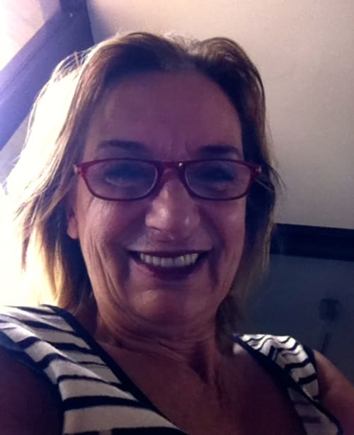 Responsabile della struttura sorridente presso l'hotel Casa_B a Erba, Italia, con occhiali viola e camicia a righe