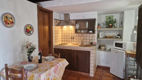 Cozy cottage kitchen and dining area at Casonas de Marengo in Icod de los Vinos with wooden cabinets and rustic décor