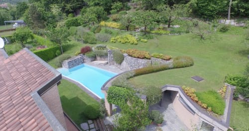 Vista aerea della lussuosa proprietà Casa_B a Erba con piscina turchese, giardini curati e villa con tetto rosso