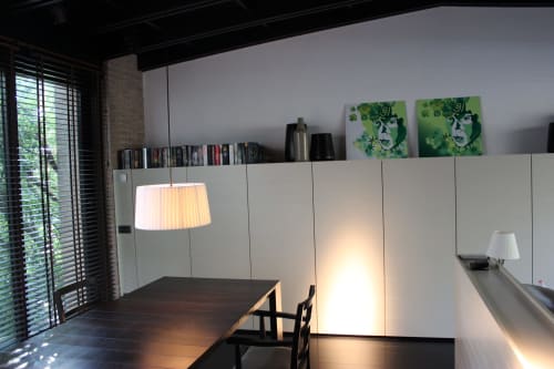 Sala da pranzo moderna dell'hotel Casa_B a Erba con mobili bianchi, illuminazione a sospensione e opere d'arte contemporanea