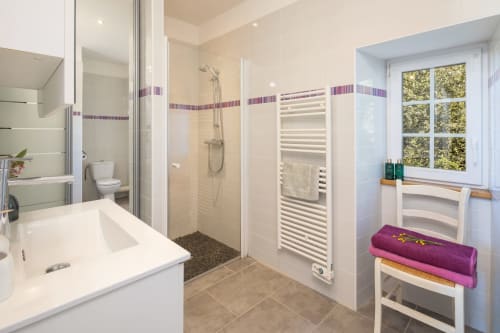 Moderne badkamer in cottage Domaine De Campagnac met inloopdouche, wit wastafelmeubel, verwarmde handdoekrek en helder raam met uitzicht