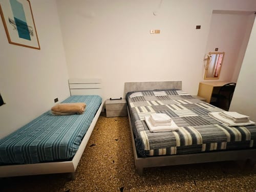Camera doppia con due letti singoli e biancheria a righe presso il Vecchie Mura B&B di Varazze