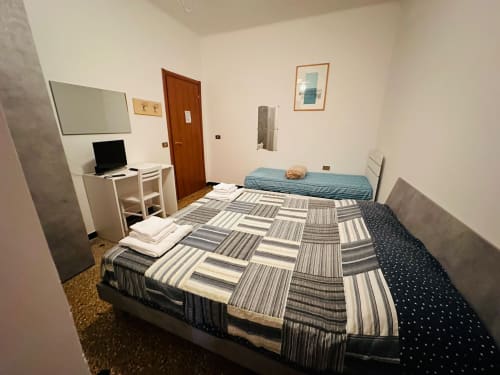 Camera compatta al BnB Vecchie Mura di Varazze con letti gemelli, scrivania, lavagna e porta in legno