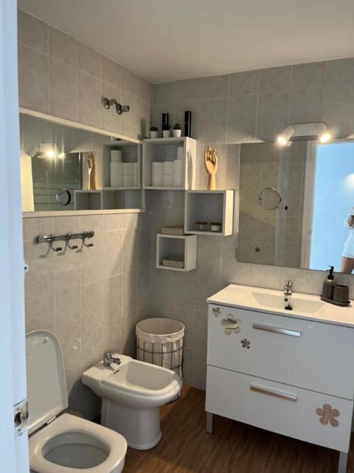 Baño moderno en Kandy Apartment, Mijas con vanidor blanco, paredes alicatadas, estantería de almacenaje y vistas al mar