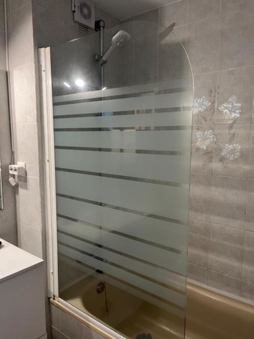 Moderno plato de ducha con puertas de cristal satinado y rayas horizontales en el Apartamento Kandy, Mijas