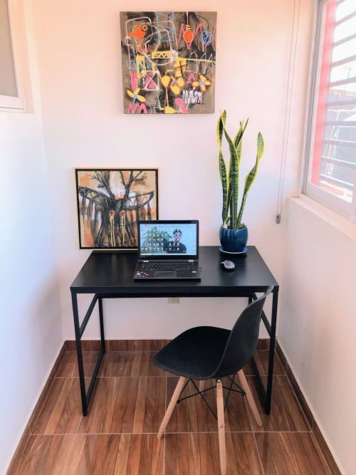 Espacio de trabajo moderno en Alojamientos Zoogocho con laptop, escritorio negro, silla, planta serpiente y arte en San Andrés Huayapam.