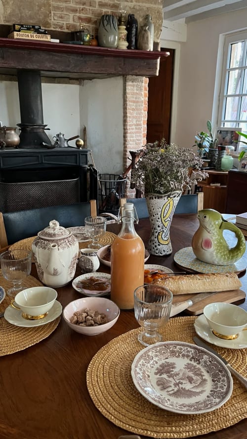 Elegant dining table setting at Domaine de Blanvatel B&B with vintage teacups, fresh flowers, and traditional French décor
