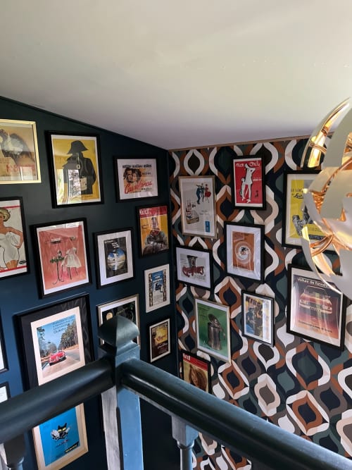 Vintage movie posters and framed artwork displayed on geometric patterned walls at Domaine de Blanvatel in Saint Pierre en
