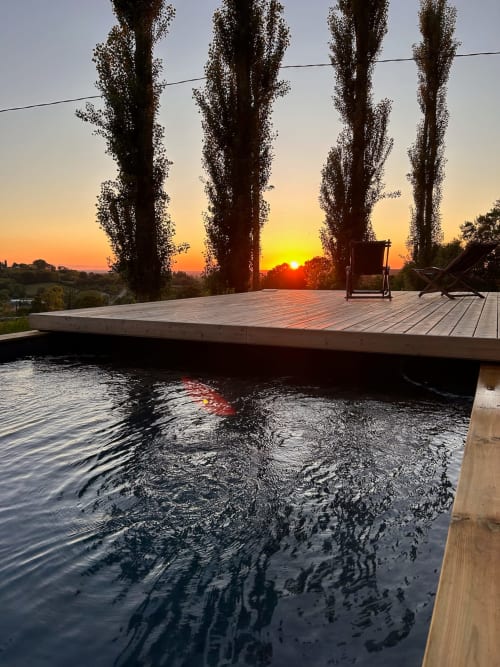 Wooden deck overlooking pool at sunset, tall poplar trees, Domaine de Blanvatel B&B, Saint Pierre en Auge