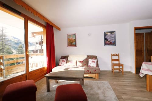 "Vue panoramique du salon de l'appartement 301 à Vars-les-Claux, mettant en valeur l'espace ouvert et la décoration moderne, avec une ambiance chaleureuse et accueillante après une journée de ski."