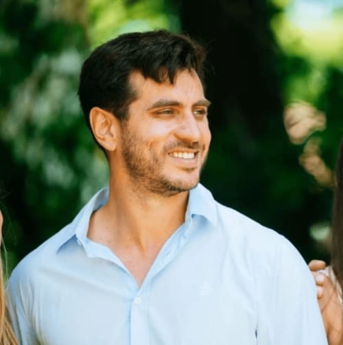 Smiling property manager at Marbella Home Rentals in light blue shirt outdoors with greenery backdrop