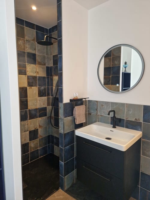 Salle de bain moderne à la Maisonaurinko B&B à Thenon avec douche carrelée, vasque et miroir rond