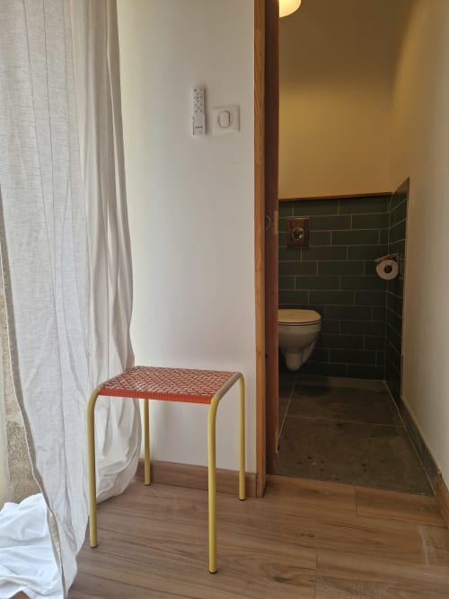 Entrée de chambre Maisonaurinko B&B à Thenon avec tabouret, rideau, interrupteur et salle de bain au carrelage vert