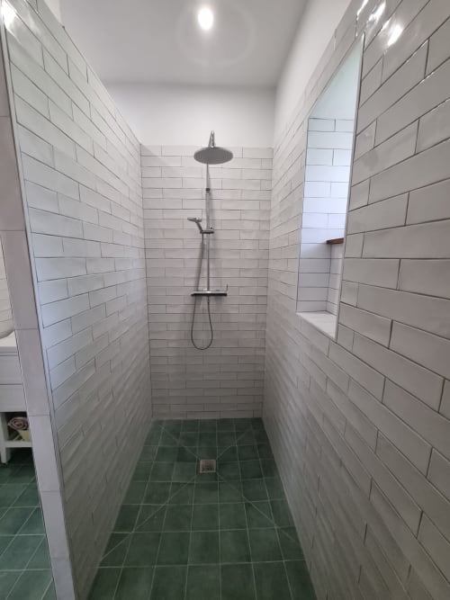 Salle de bain moderne avec carrelage blanc métro, pomme de douche pluie et sol en carrelage vert à la Maisonaurinko B&B