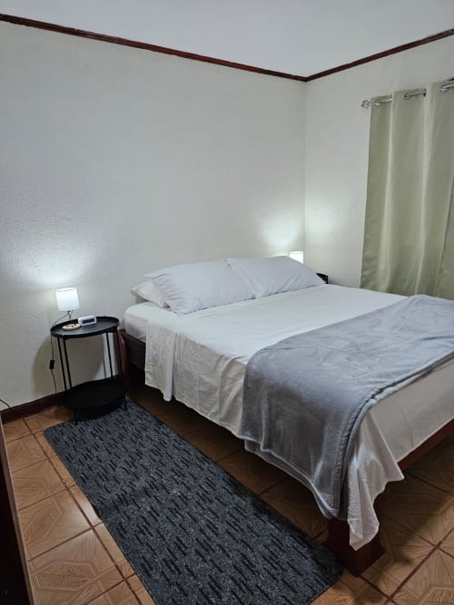 Disfrute de una cama queen-size con un colchón de alta calidad, sábanas suaves y almohadas mullidas que garantizan un descanso reparador. La cama, vestida con ropa de cama, invita a una noche de sueño profundo y tranquilo.