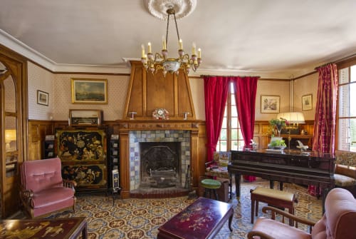 Salon avec cheminée, piano, radio ancienne, gramophone à pavillon, lustre en porcelaine et carreaux de ciment décoratif au Domaine des Thomins Maison d'hôte Cisai Saint-Aubin Hôtel Gacé