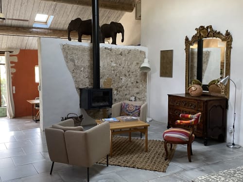 Coin salon douillet de l'Appartement Éléphant au Mas du Fort, Gargas, avec fauteuil crème, cheminée et miroir orné