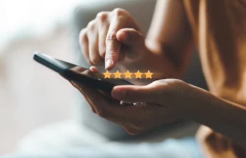 Client donnant une note de cinq étoiles sur smartphone à La Maison du Plaisir, Isigny sur Mer