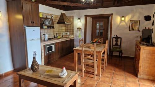 Rustic cottage kitchen and dining area at Casonas de Marengo, Icod de los Vinos, with wooden table, equipped kitchenette, and