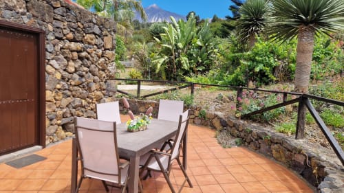 Terrace dining area at Casonas de marengo with mountain views, stone cottage, and tropical garden in Icod de los Vinos