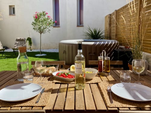 Table élégante dressée à la villa Tiny Harmony à Venelles avec vin, appetizers et bain à remous gonflable