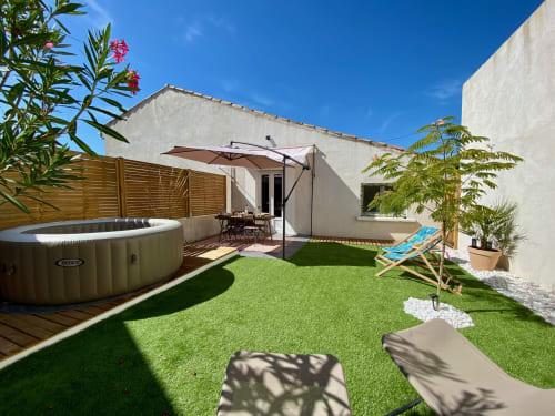 Jardin de la villa Tiny Harmony avec bain à remous, transats, parasol et hébergement aux murs blancs à Venelles