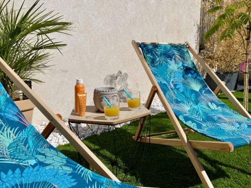 Espace détente à la villa Tiny Harmony avec chaises longues bleues, crème solaire et boissons sur table