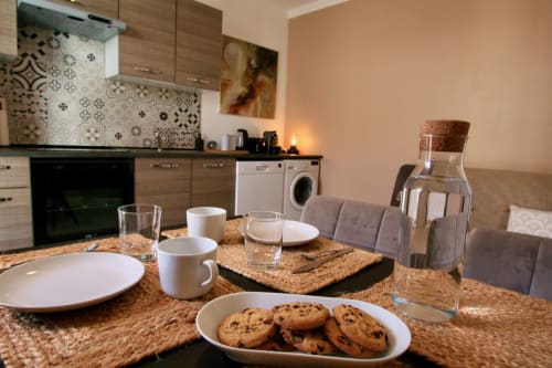Cuisine-salle à manger contemporaine à la villa Tiny Harmony à Venelles avec plan de travail en granit, pâtisseries et vue sur le jardin