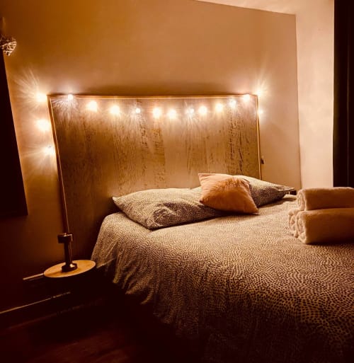 Chambre cosy de la villa Tiny Harmony avec guirlandes lumineuses, tête de lit en bois et literie beige chaleureux à Venelles, France